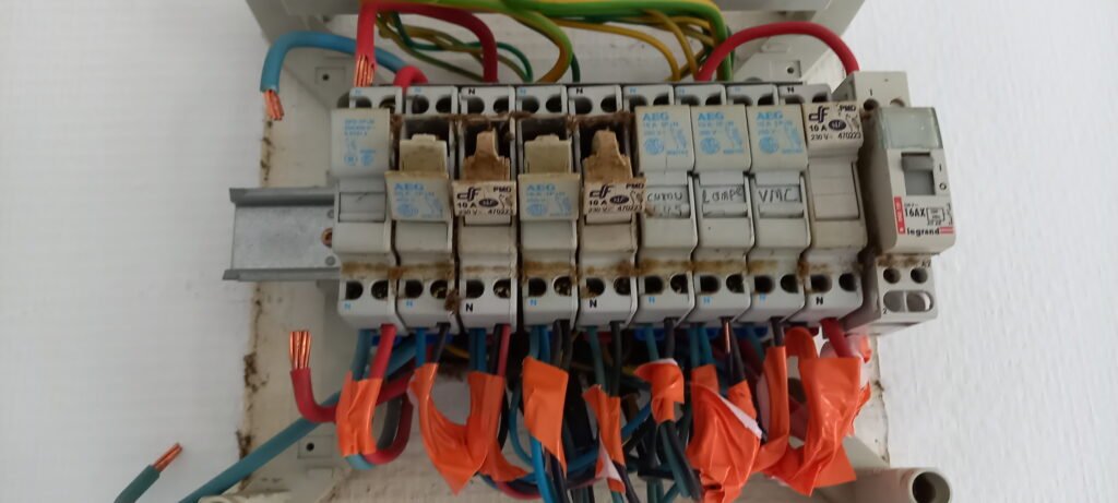 Installation électrique vetuste avec disjoncteurs et câblage – intervention Rapido Travaux pour rénovation et sécurisation du tableau électrique.
