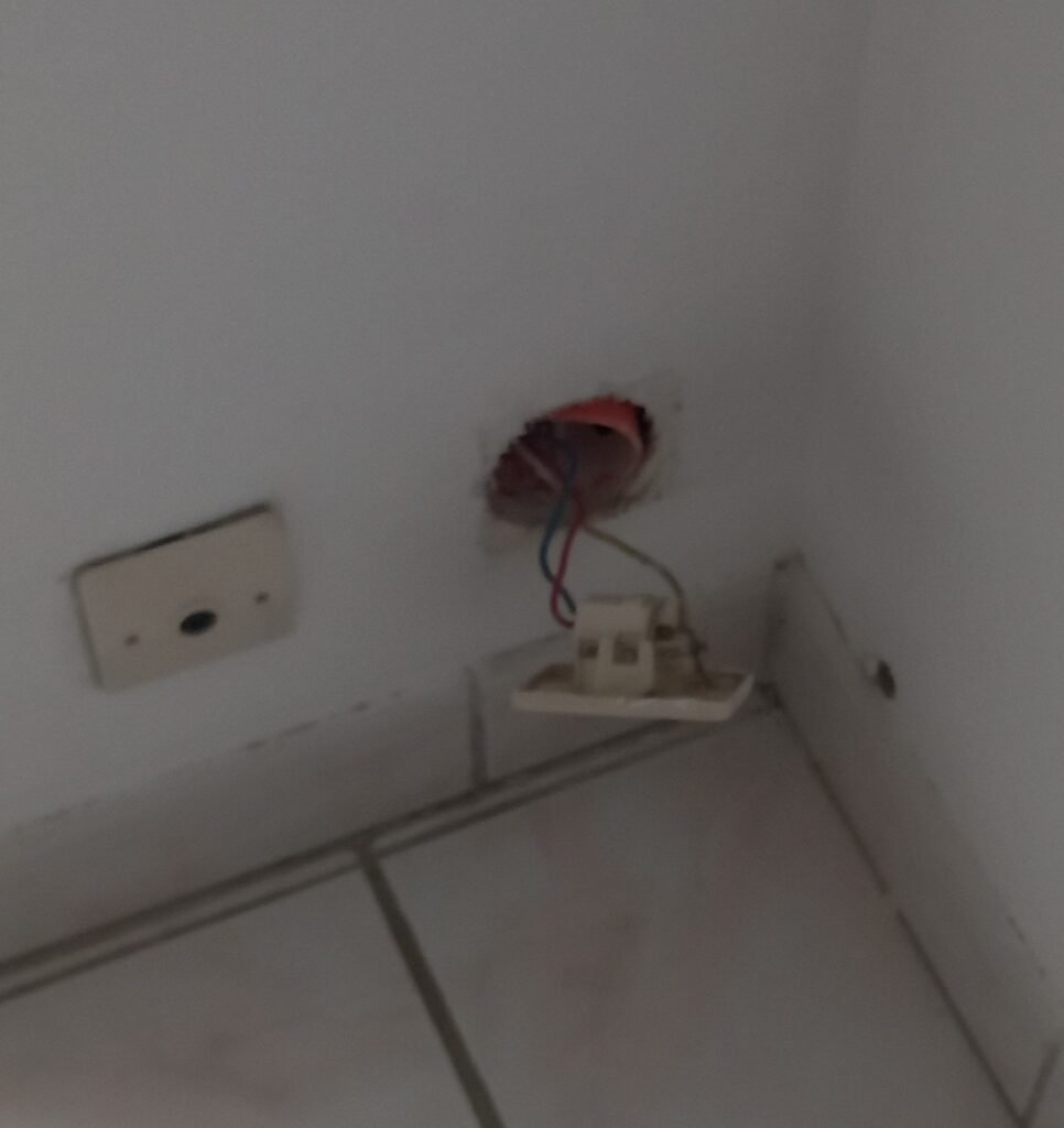 Prise électrique murale cassée avec fils apparents remise en conformité par Rapido Travaux – réparation et sécurisation d’installation électrique.