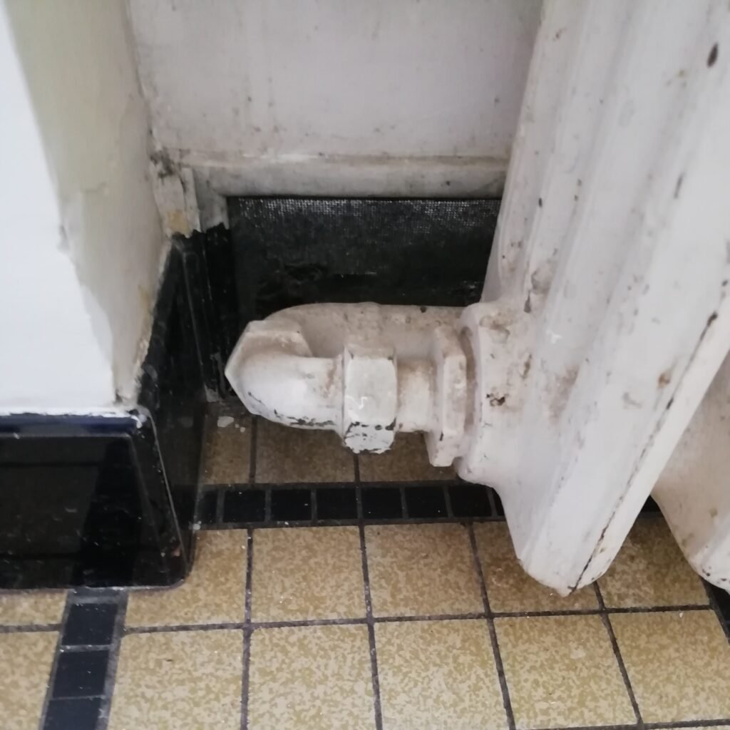 Radiateur en fonte ancien qui fuit nécessitant une réparation par un plombier